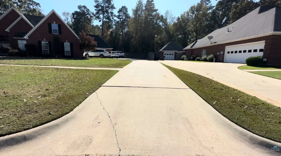 Technician pressure washing a stained residential driveway in Jacksonville, FL